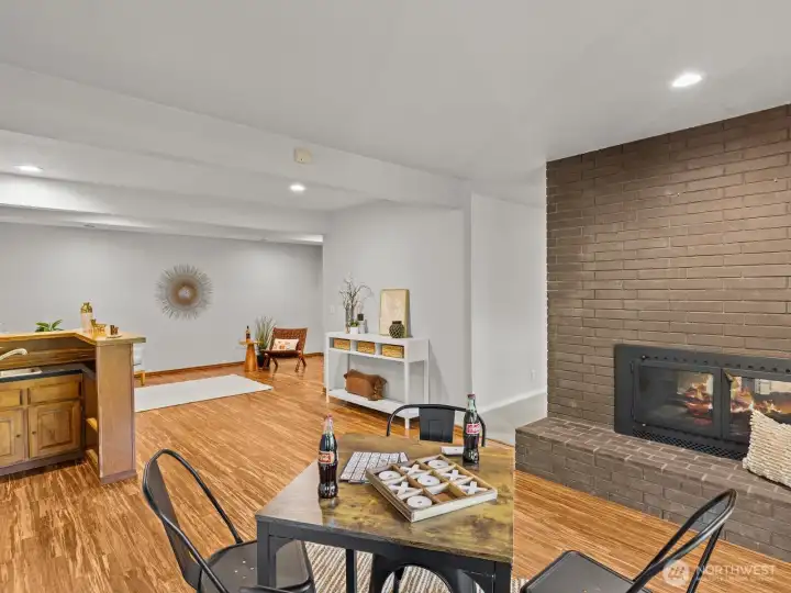 A wet bar is centralized in the space nearby, nicely separated by another gas fireplace.
