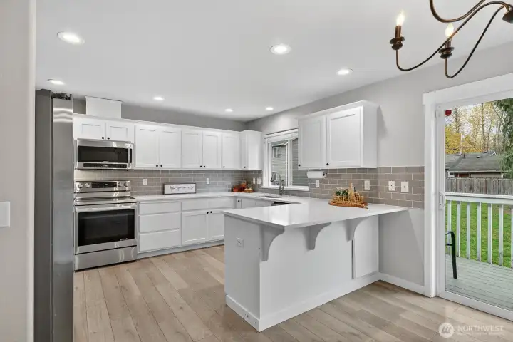 Bright, functional kitchen featuring quartz countertops, plenty of storage, and room for meal prep or casual dining.