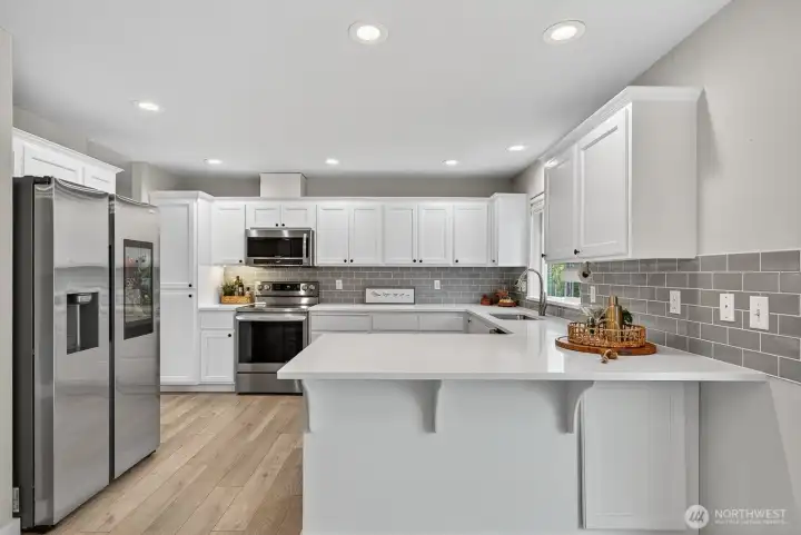 Modern kitchen designed for efficiency and style, offering expansive quartz counters and impressive cabinet storage throughout.