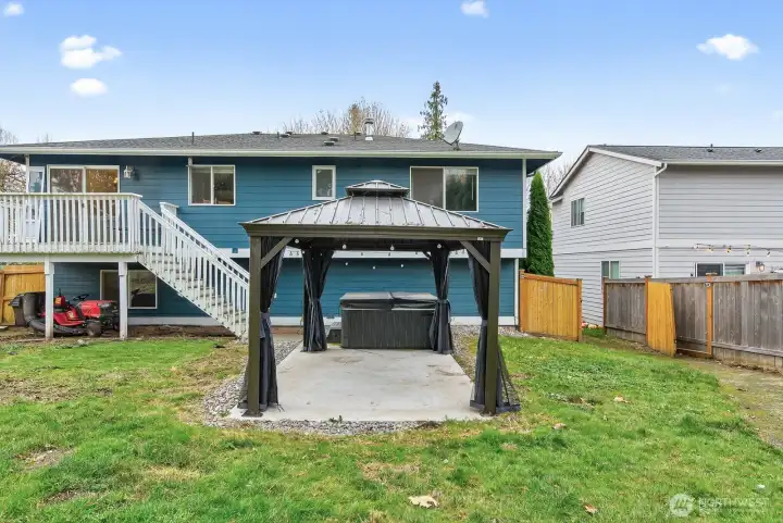 Perfect setting for gatherings—large backyard with hot tub and covered gazebo, overlooking peaceful setting.