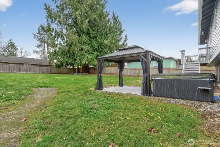 Outdoor living at its best! Relax in the hot tub, host under the gazebo, and enjoy the serene open space beyond the yard.