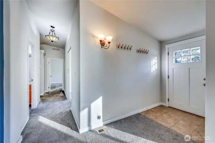 Down the hall from the entry leads to second full bath, den, guest room and primary bedroom.