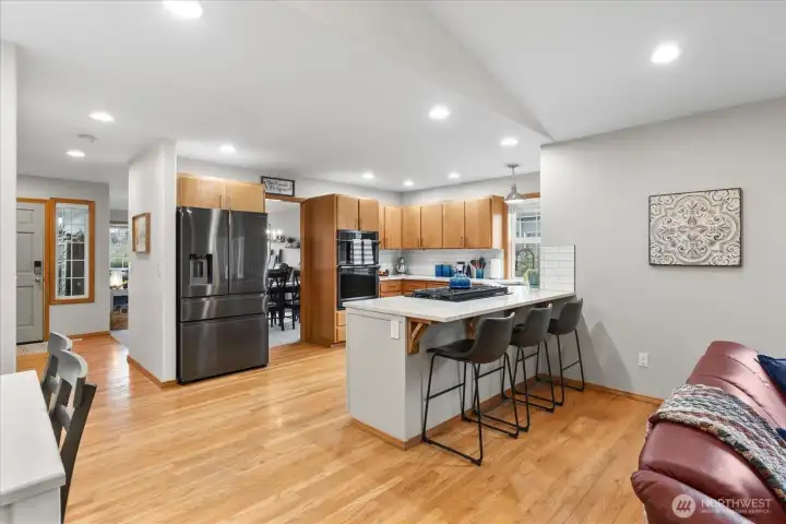 Spacious kitchen with wood cabinetry, stainless steel appliances, and a center island with gas cooktop. Ample counter space and recessed lighting support everyday functionality.