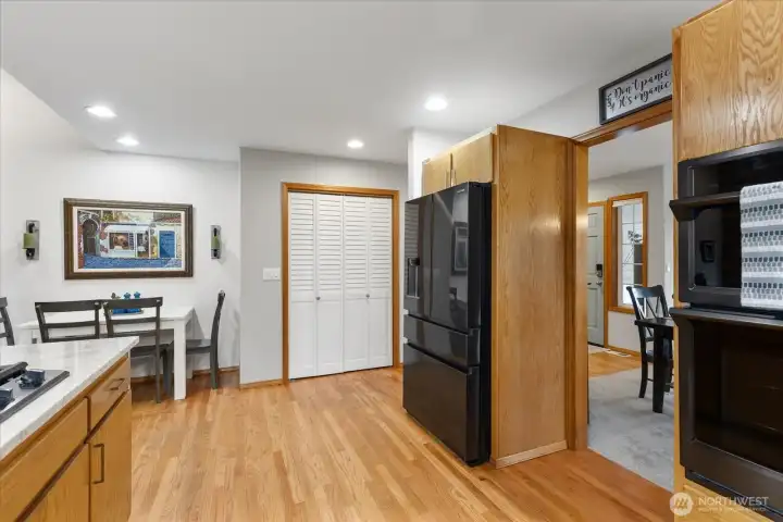 Kitchen with stainless steel appliances, built-in double oven, and wood cabinetry. Dining nook offers room for seating.