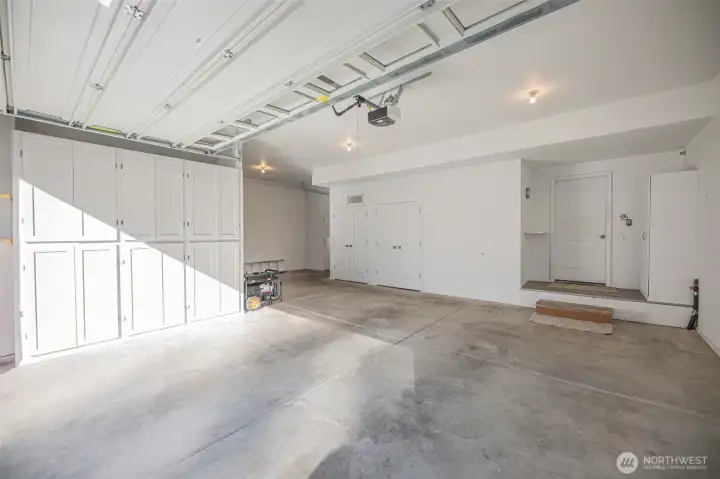 3 car garage with custom cabinets for added storage.