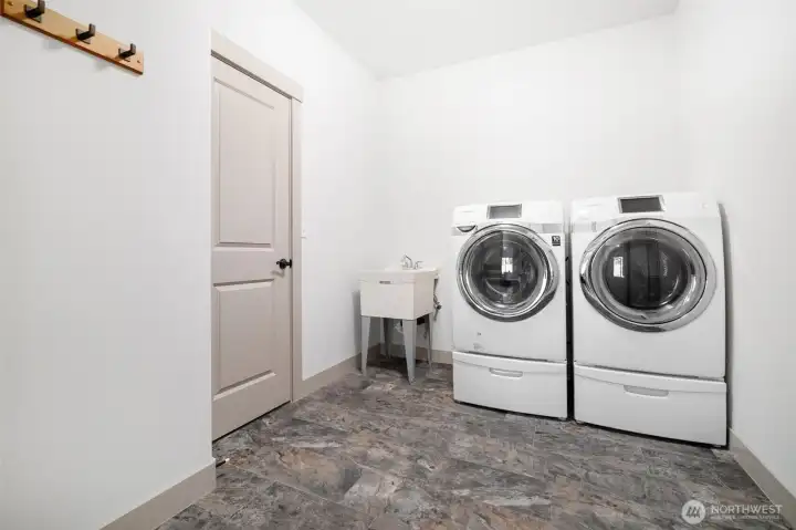 Laundry space with garage access, functioning as a mud room with storage closet.