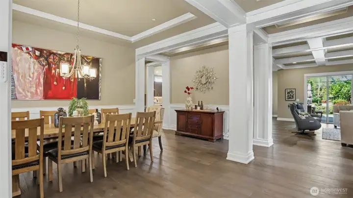 Welcoming entry with beautiful open dining room is adorned in wainscoting and painted cased openings while illuminated by an elegant chandelier.