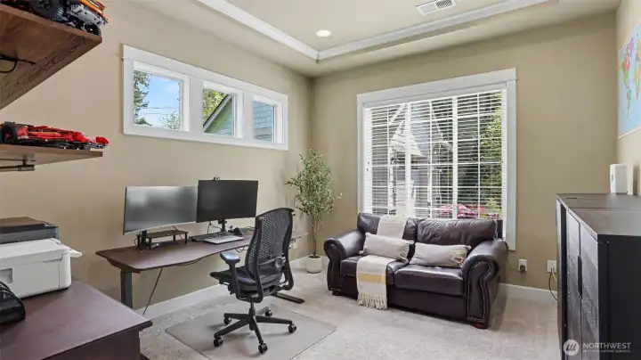 Handsome den is enhanced by a large sunlit window and a coffered ceiling with crown molding.