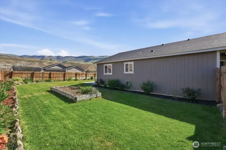 Side yard with raised garden bed.