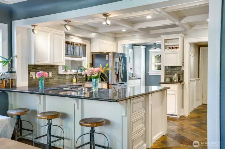 Bar seating at the kitchen. Coffered ceilings, canned lighting and newer kitchen appliances