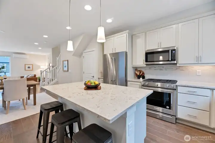 Chef-style Kitchen featuring a 5-burner gas range and an oversized quartz island with additional seating-perfect for everyday cooking and effortless entertaining.