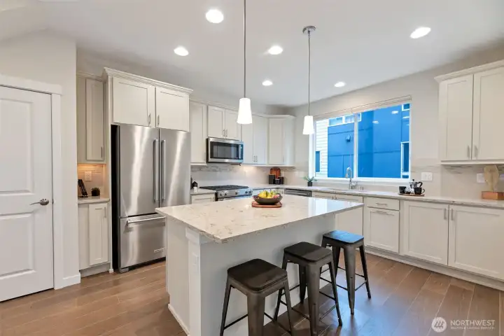 Bright and cheerful kitchen with pantry, tons of cabinet space, smart pull-out drawers, ample storage, and elegant under-cabinet lighting that enhances the space