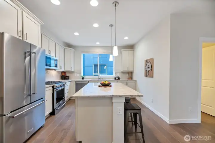 Light and airy kitchen with a large window, plenty of natural sunlight, and numerous recessed lights