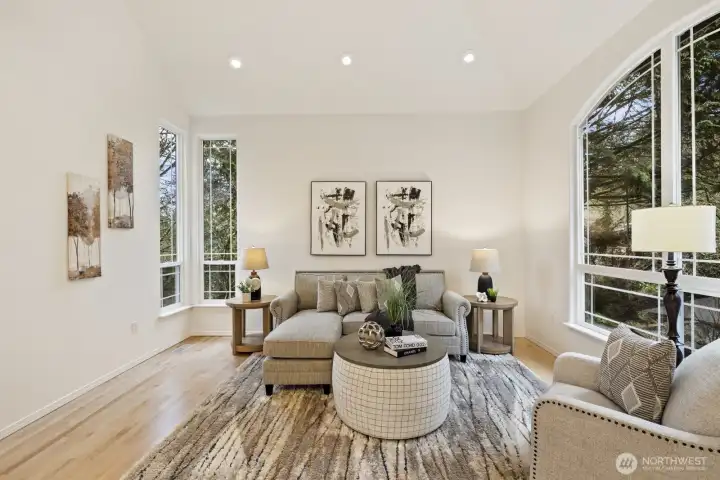 Formal living room with vaulted ceilings and picturesque windows.