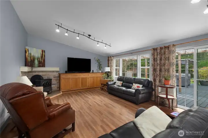 Spacious living room with cozy wood stove with sliding glass door to deck.