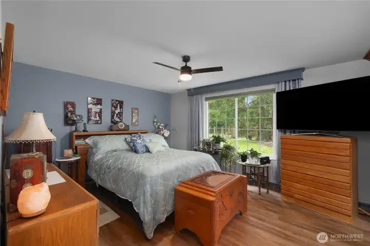 Primary bedroom featuring an ensuite bath with views of the property.