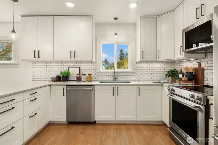 REmodeled kitchen with quartz counters, white soft-close cabinetry, SS applicaces & large island.