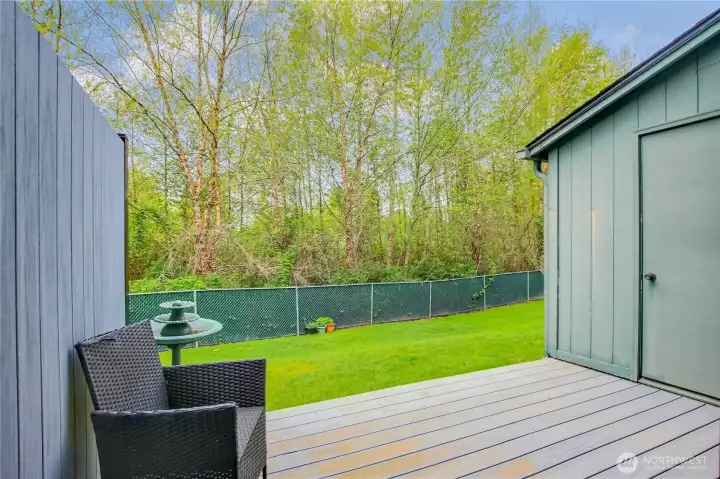 Private deck look out green lawn and has storage