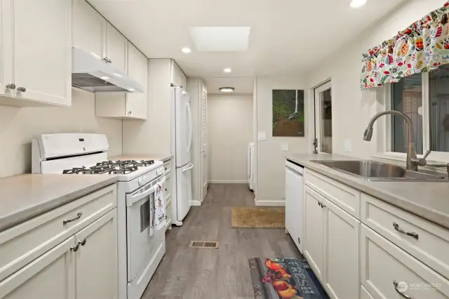 Remodeled kitchen with a gas range, laminate floors, new soft close and slide out cabinets and skylight.