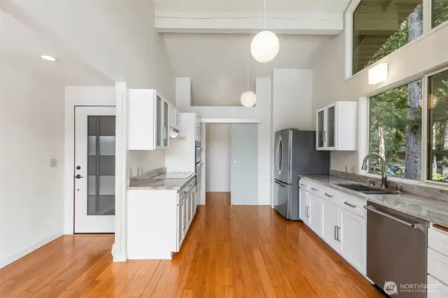 Galley kitchen with new appliances, countertops and cabinets. Walk-in pantry to the back.
