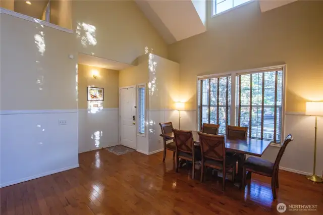 As you enter the front door, you're immersed with natural light from the many windows and high ceilings. Refreshed custom paint and custom window blinds enhance the beautiful gleaming hardwood floors throughout this large living and dining room area.