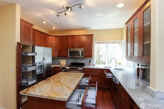 The light and bright kitchen has beautifully updated custom cabinets and countertops with amazing organization pull-out drawers and shelves, along with stainless appliances and gas stove/oven.