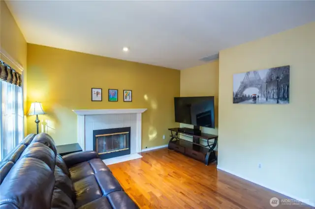 Another view of the family room with beautiful hardwood floors and cozy gas fireplace.
