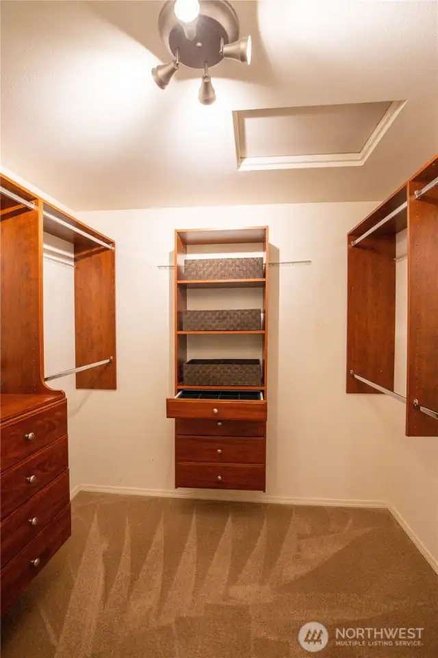 The large primary walk-in closet has custom built-in closet organizers and drawers.