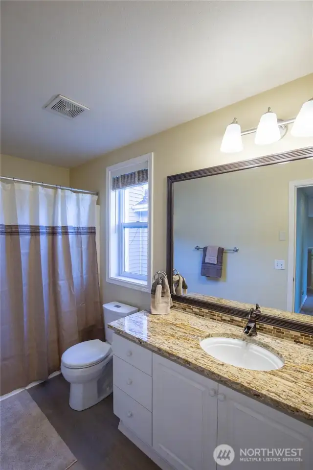 The full main bathroom has beautiful and tasteful updates with granite countertop, newer fixtures, toilet and new LV tile flooring, and is within steps from bedrooms 2-4.