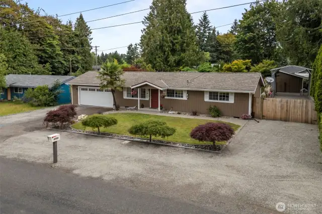 4709 144th St E, Tacoma! Viewed from the street with visible covered and RV parking along the side