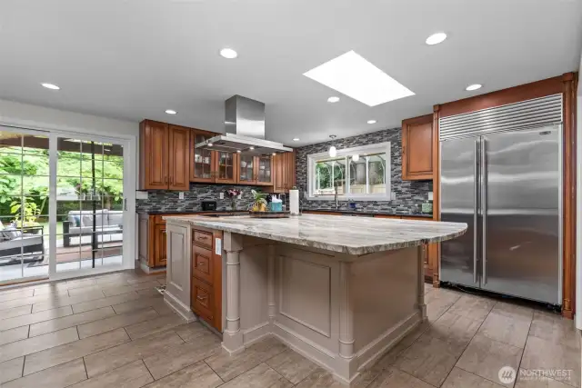 Chef's kitchen featuring custom cabinetry and a glorious granite slab island! High-end Miele, Subzero & Thermador appliances all stay