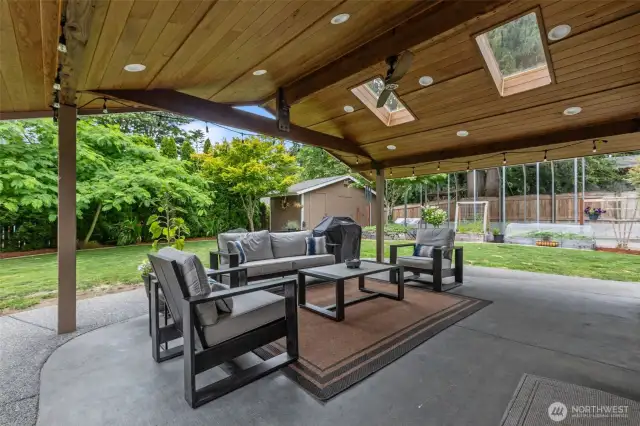 Your private backyard oasis awaits. Enjoy a huge covered patio for entertaining and stunning landscaping with built-in fire pit, water feature, and a ton of lush native and non-native plants! Two generously sized outbuildings provide ample additional storage