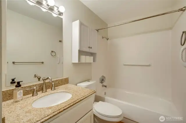 A full bathroom with storage.