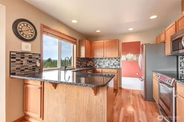 The remodeled kitchen boasts granite counters with raw edge, backsplash, stainless appliances and expansive view.  Even a spacious pantry.