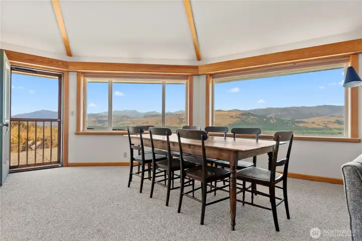 Panoramic dining with views that stretch for miles—an inviting space for memorable meals with family and friends. Patio door opens to fresh air and sunshine, complemented by warm clear fir trim framing every view.