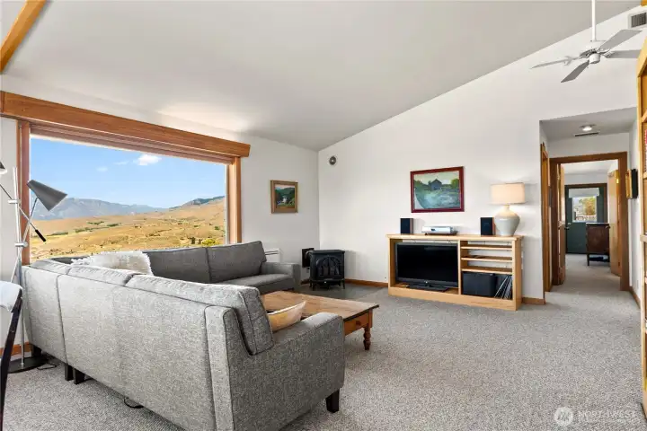 Bright, comfortable living space with sweeping valley views, a freestanding propane stove, and efficient heating & cooling systems—heat pump, forced air, and AC.