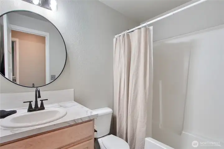 Hall bathroom has updated countertops and fixtures.