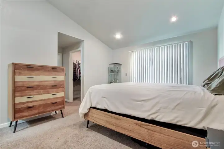 Primary suite is located at the end of the hallway. Sliding door takes you out to the spacious back patio. The room features vaulted ceilings, walk-in closet and bathroom