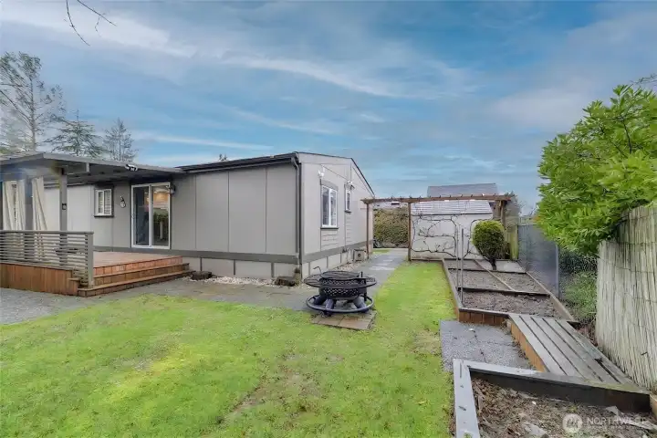 Large side/backyard offering ample space for gardening, a fire pit, and additional outdoor entertaining or storage options