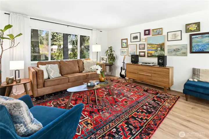 The living room is upstairs on the main level and has large windows to let in natural light.