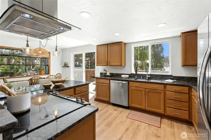 Note the beautiful hardwood cabinets, recessed lighting, stainless appliances (including new dishwasher), and range hood. The window over the sink looks over the upper deck and back yard.