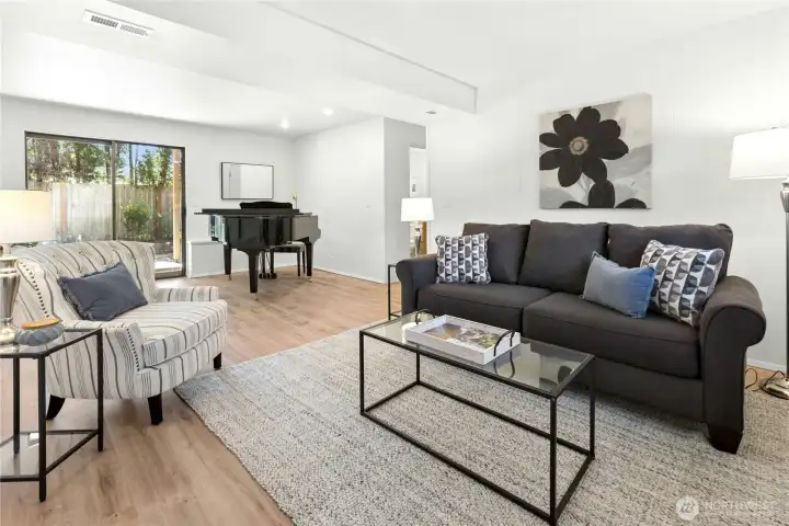 The large family room has luxury vinyl tile flooring and a sliding door to the covered back patio.