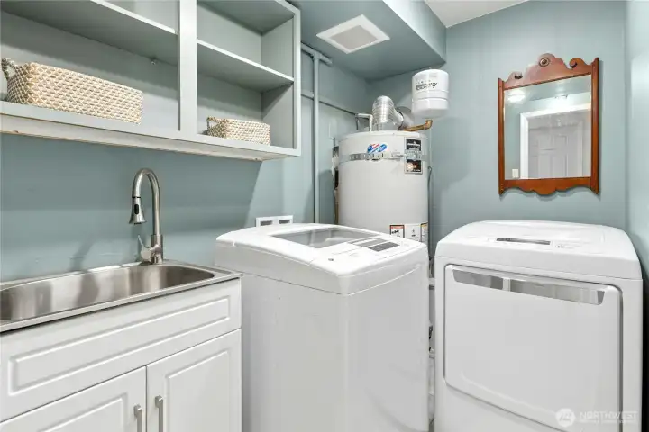The laundry room includes a washer, dryer and sink.