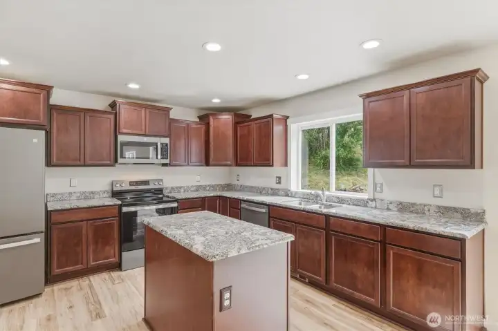 Stunning granite kitchen with maple cabinetry in a cherry finish