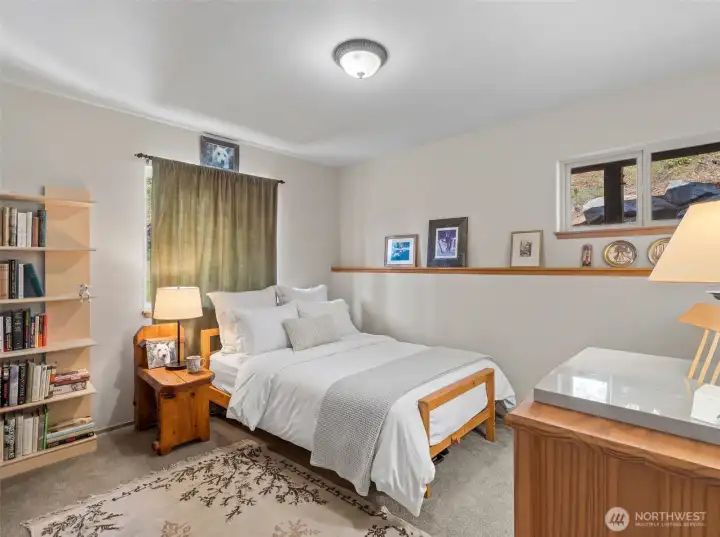 2nd main floor guest bedroom is spacious with great closet space and wooded views.