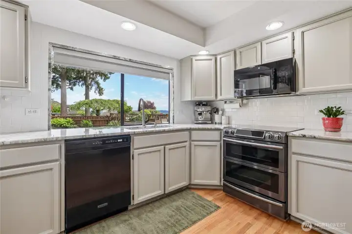 Functional kitchen layout with double oven, classic subway tile backsplash, and a beautiful view of Mt Rainier.