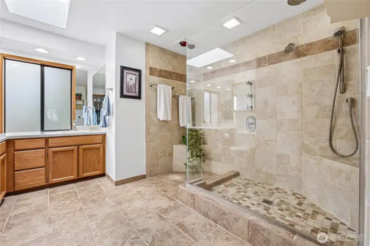 Primary ensuite bath with dual sinks and luxurious heated tile floor