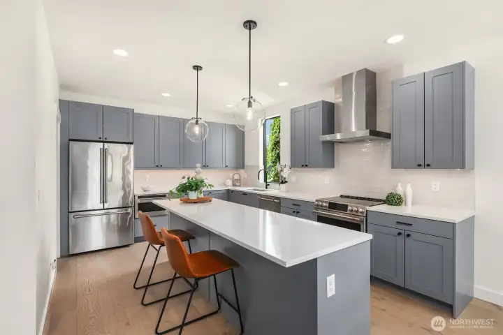 The large, gorgeous kitchen with abundant cabinetry, plenty of a working surfaces, a large pantry and a large eating bar that can easily seat 4