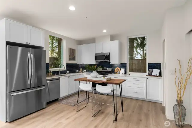 A culinary haven awaits with this stunning kitchen. This space blends functionality with modern design, featuring a sleek stainless steel appliance and a chic navy tile backsplash. Perfect for casual meals or hosting with style.