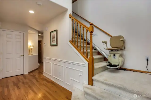 Entryway with wainscotting, hardwood floors and access to second level